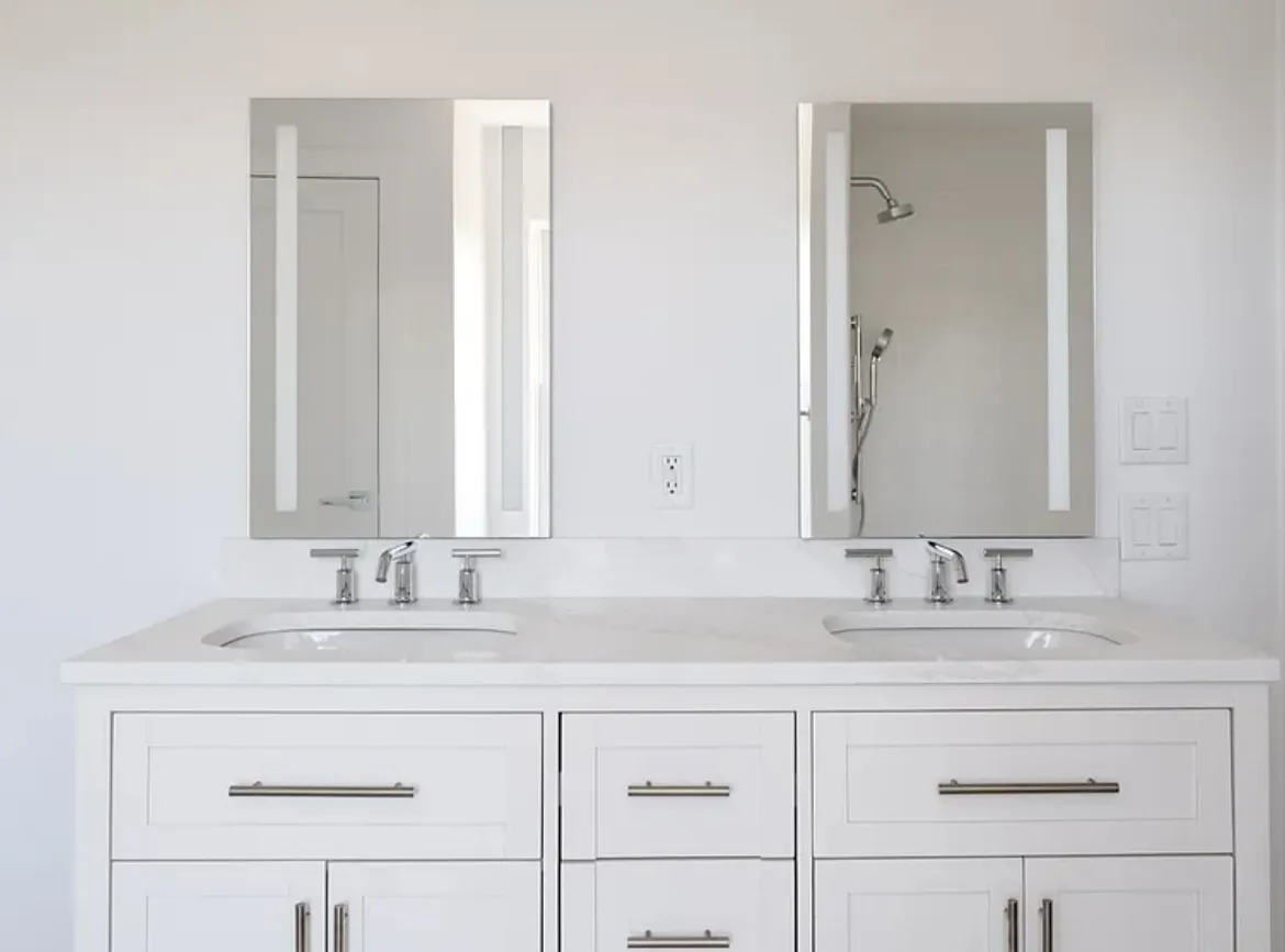 22 Tashama Lane Nantucket primary bathroom before redesign with plain white walls, chrome fixtures, and frameless mirrors